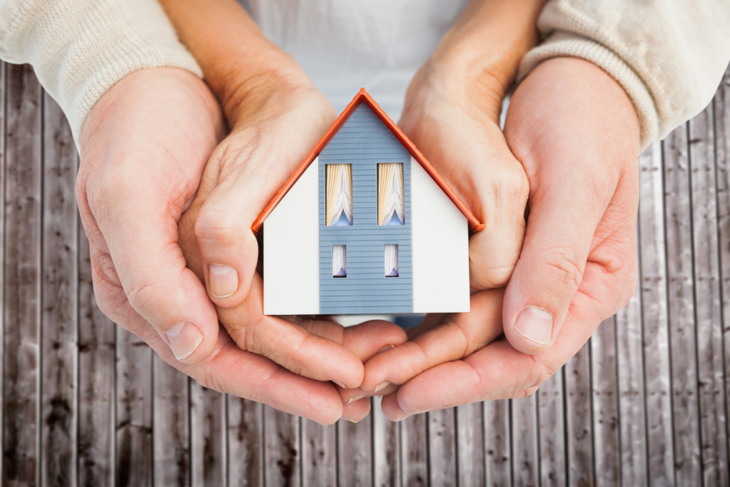 Couple holding model house
